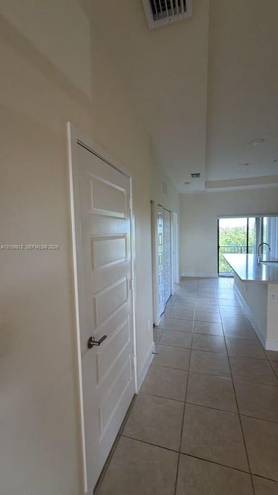 Ceramic tile flooring, five-panel interior doors, recessed ceiling lighting, and a kitchen peninsula with a stone-surface countertop