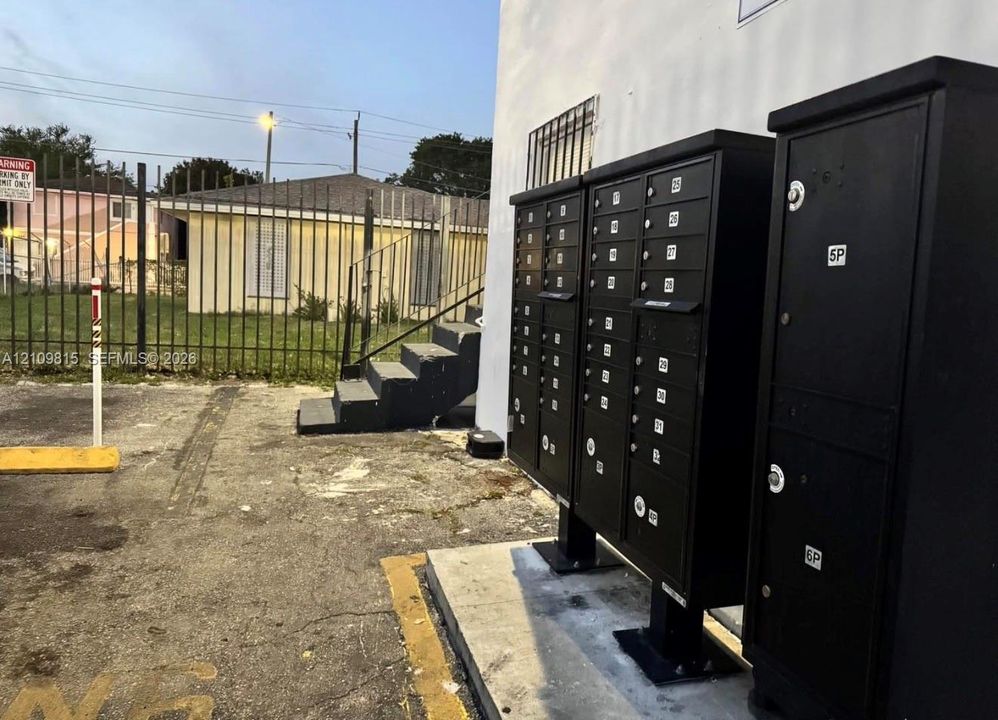 Black metal cluster mailbox units mounted on a concrete pad