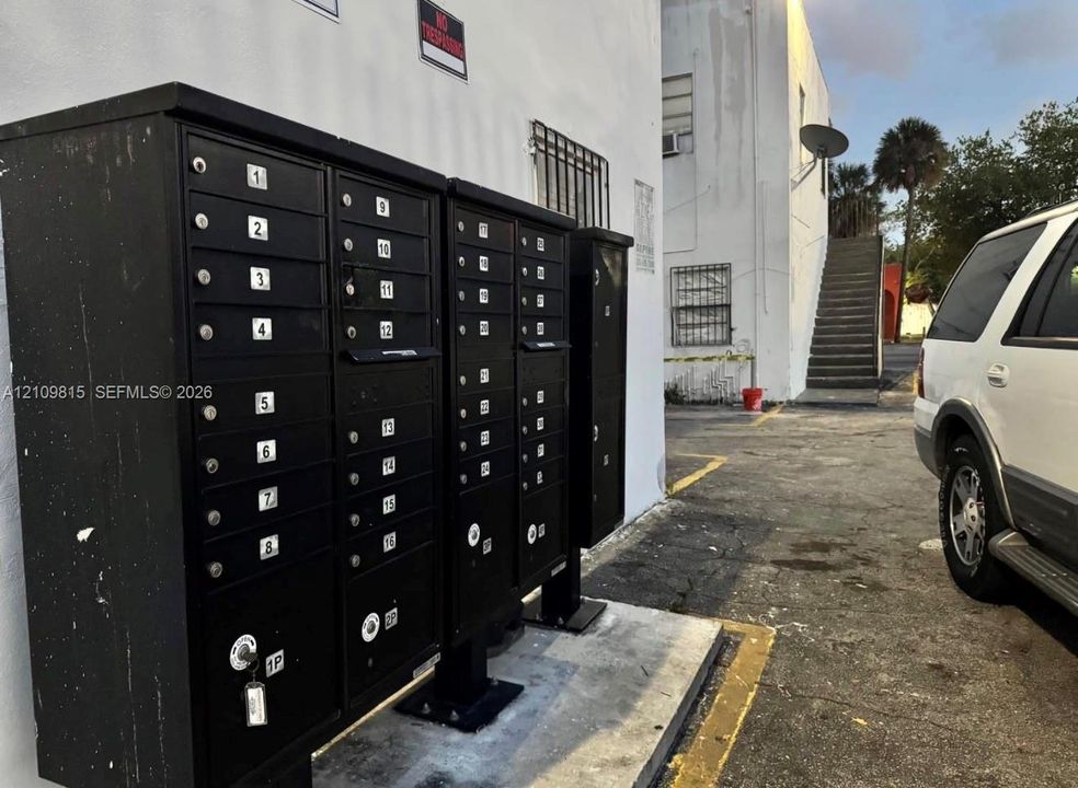 Multi-unit black steel mailboxes secured on a concrete platform