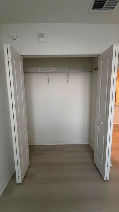 Closet featuring white bi-fold doors, interior wire shelving, and wood-finish flooring