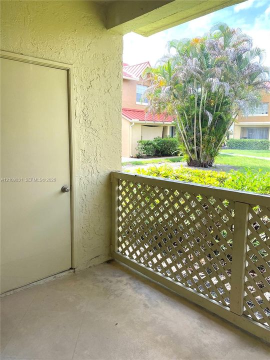 Covered balcony featuring concrete flooring, a dedicated exterior storage closet, and a lattice railing
