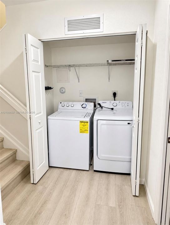 Laundry closet featuring bifold doors, wood-finish flooring, and wire shelving