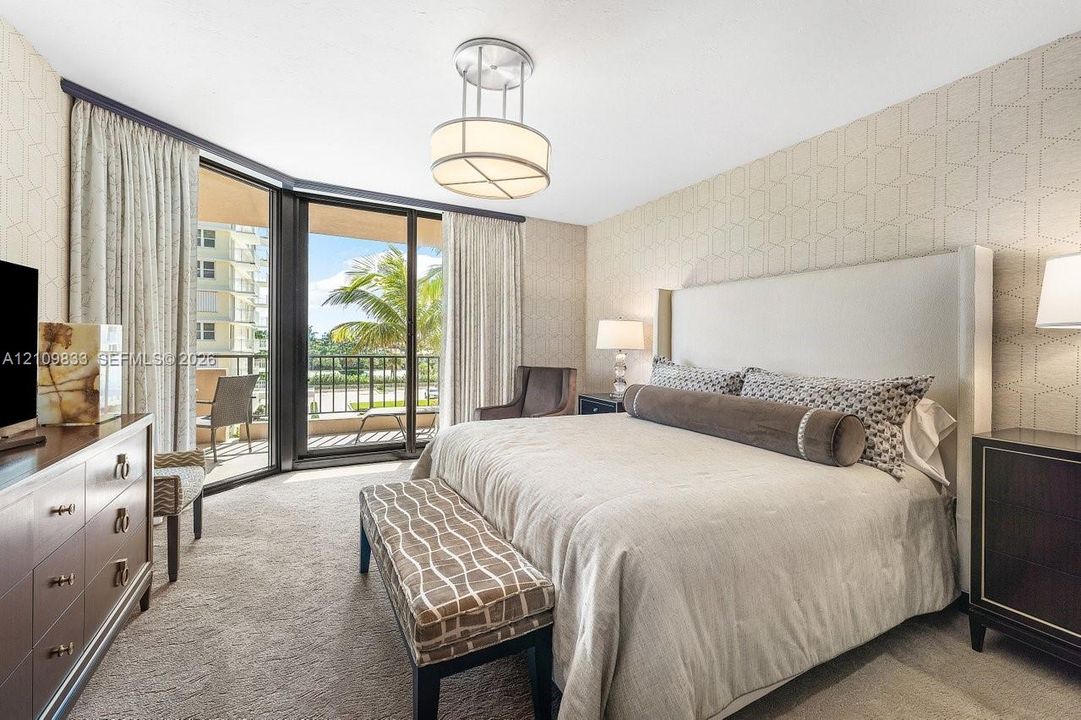 Floor-to-ceiling sliding glass doors, private balcony, patterned wall covering, carpeted flooring, and circular pendant lighting