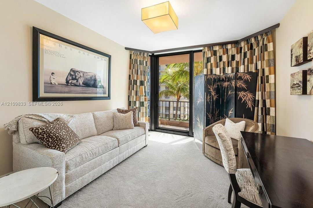 Neutral-toned carpeting, square architectural ceiling lighting, and floor-to-ceiling glass sliding doors providing access to an exterior balcony
