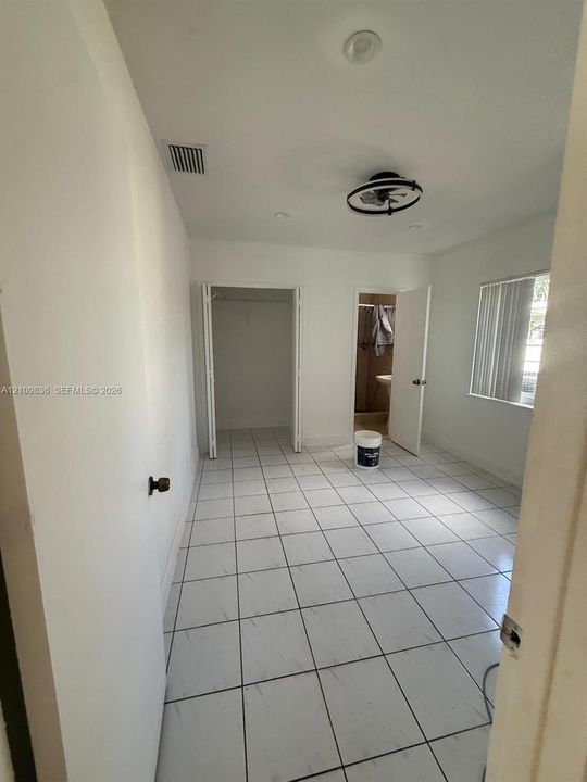Room featuring ceramic tile flooring, a dual-door closet, a modern circular ceiling light fixture, and recessed lighting