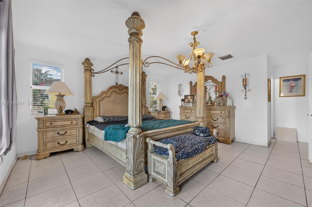 Ceramic tile flooring, multi-light metal chandelier, and double-hung windows