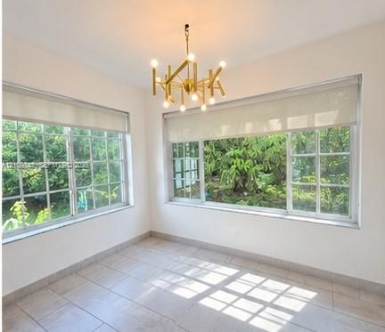 Multi-pane windows, metallic multi-arm chandelier, and large-format tile flooring