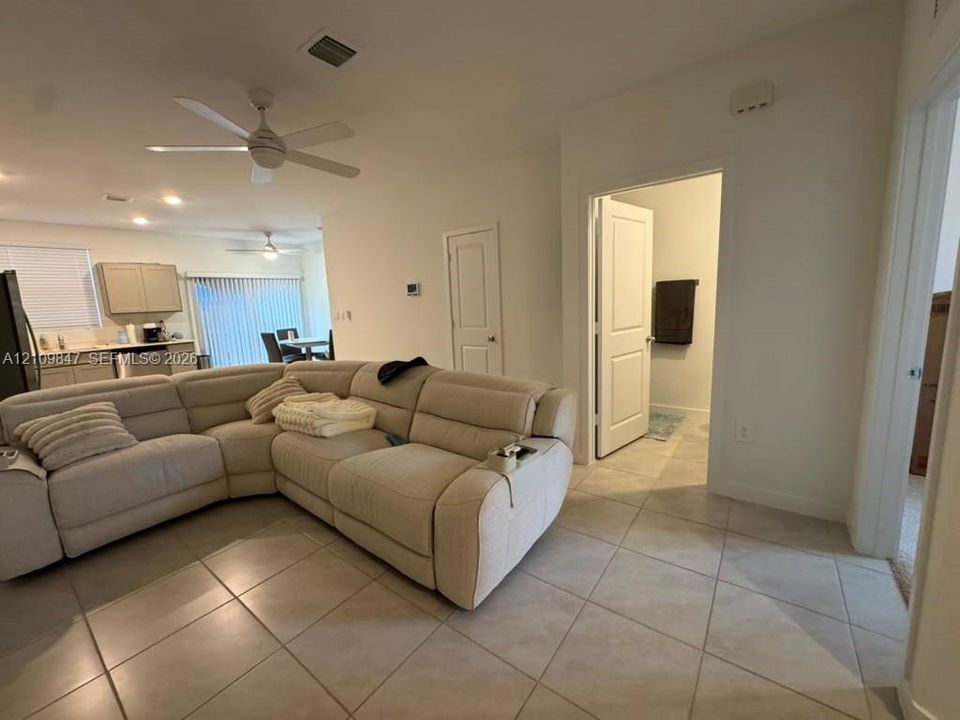 Open-concept interior featuring large-format diagonal floor tiling, neutral wall tones, multi-speed ceiling fans, and recessed lighting