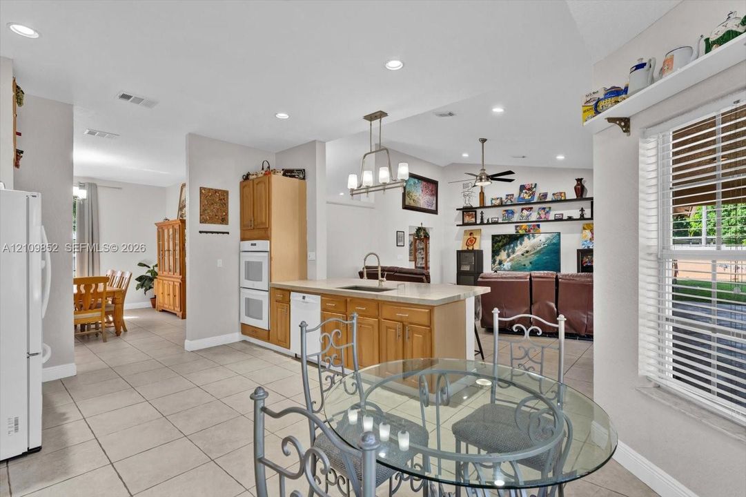 Kitchen featuring light-finish solid wood cabinetry and built-in double wall ovens *