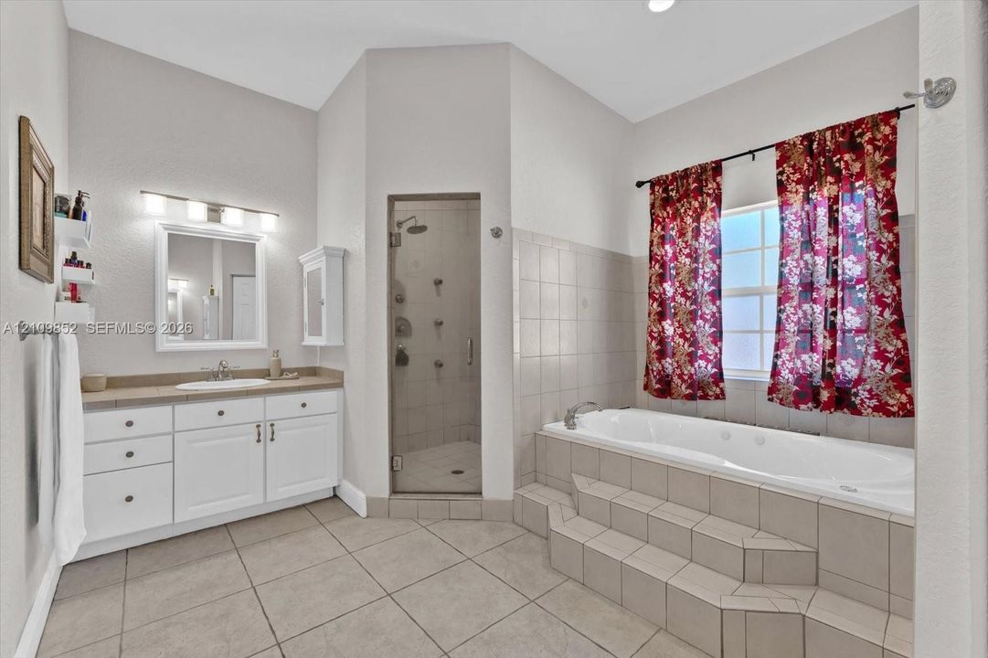 Another main bathroom with of the glass-enclosed walk-in shower with multi high powered water jets and a built-in jetted soaking tub *