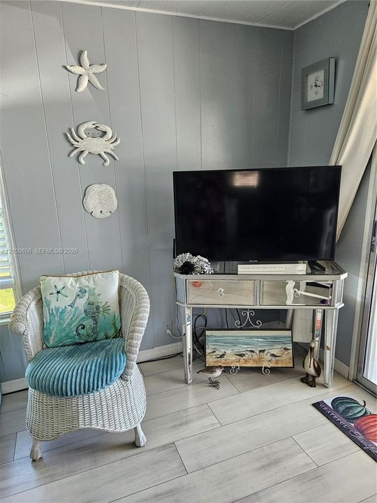 Paneled wall surfaces in neutral grey tones complemented by light-toned plank flooring