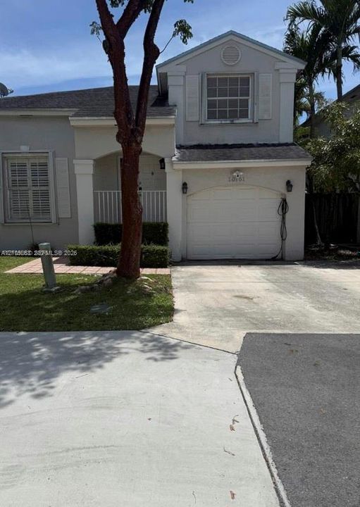 Two-story stucco exterior featuring a covered front entry, single-car garage, louvered shutters, and a tiled walkway