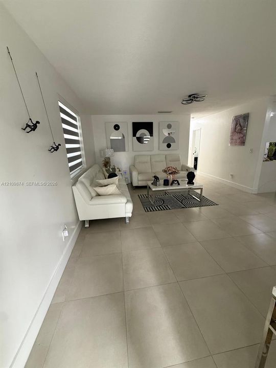 Large-format tile flooring, neutral wall palette, and dual-layered window shades