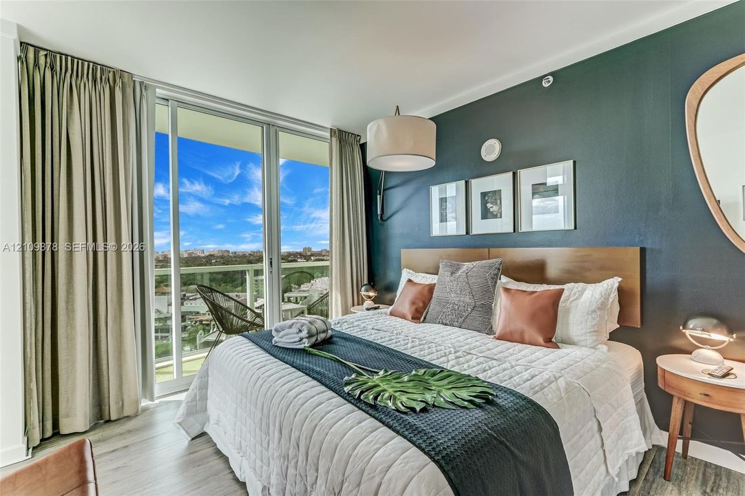 Floor-to-ceiling sliding glass door, private balcony, wood-finish flooring, and drum pendant lighting