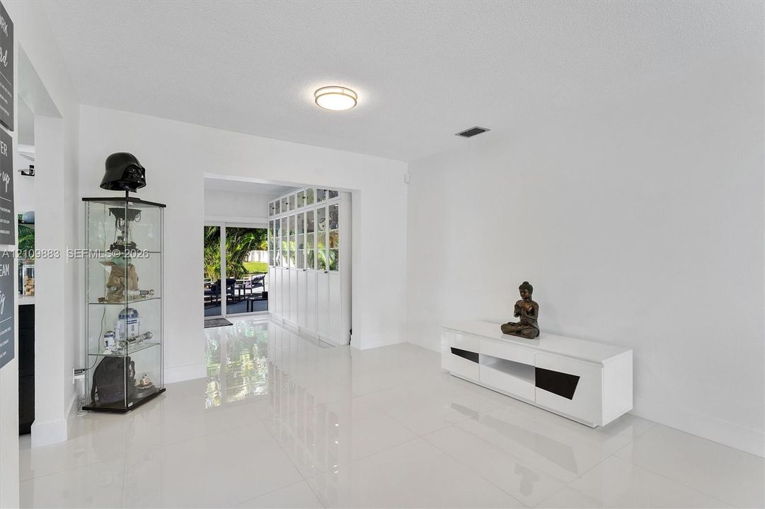 Interior space featuring polished tile flooring, recessed ceiling lighting, and floor-to-ceiling multi-panel built-in cabinetry
