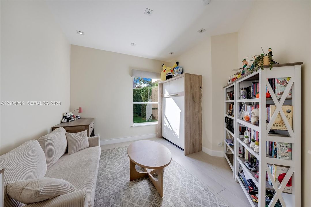 Interior room featuring neutral wall tones, wood-finish flooring, recessed ceiling lighting, and a single-pane window