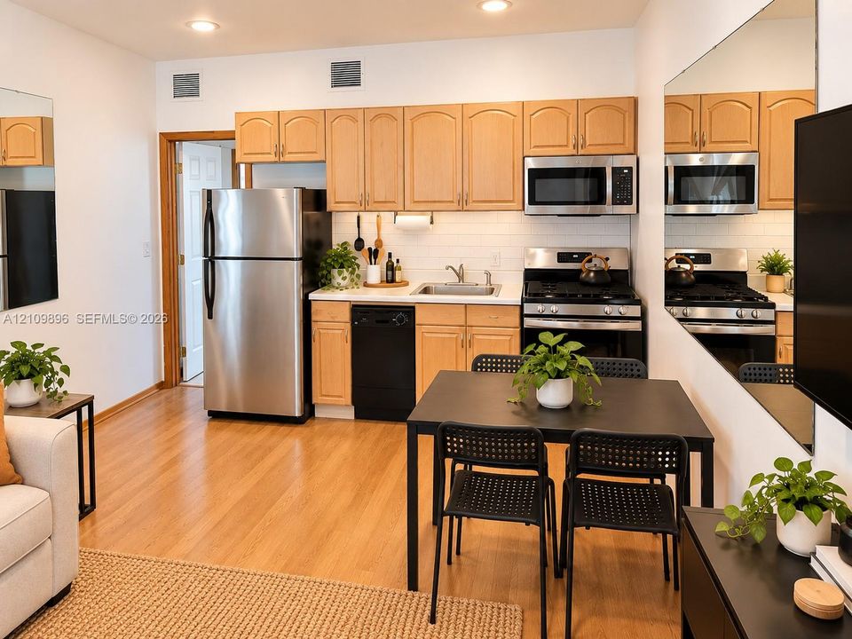 Kitchen featuring light-finish cabinetry, white subway tile backsplash, stainless steel appliances, and wood-finish flooring