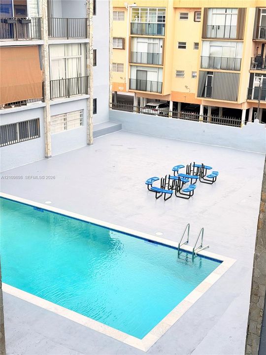 Outdoor swimming pool featuring a concrete deck and metal pool ladder
