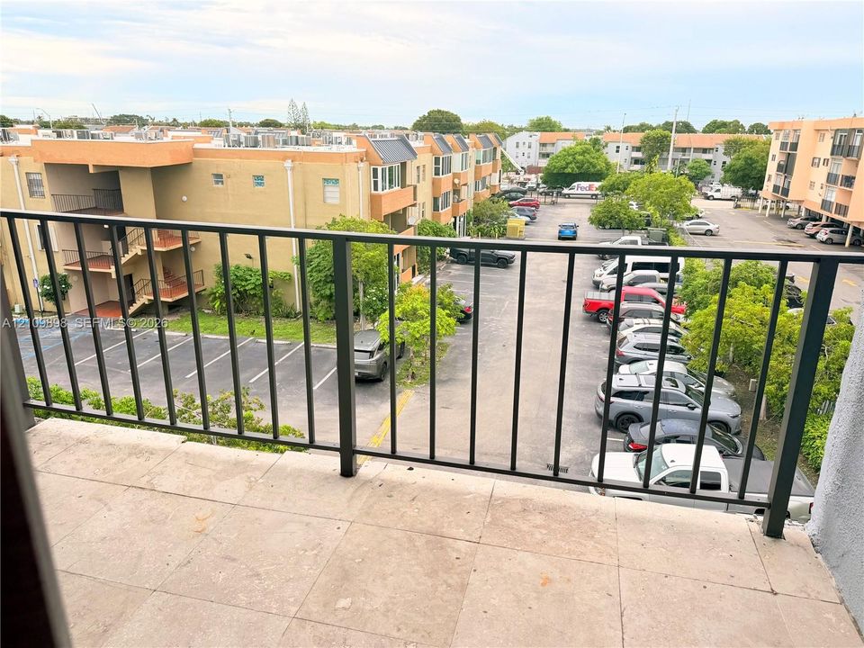 Outdoor balcony with tile flooring and a black metal railing