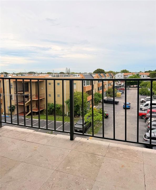 Exterior balcony featuring stone-finish tile flooring and a black metal railing