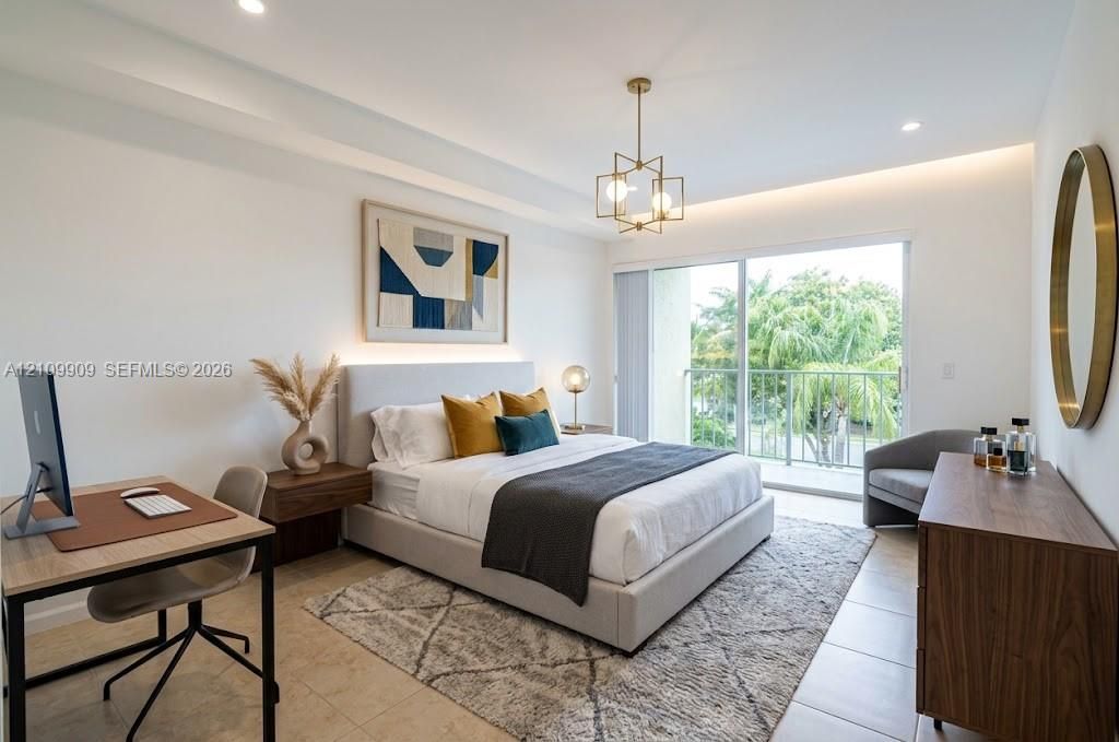 Bedroom featuring recessed ceiling lighting, a geometric brass chandelier, neutral tile flooring, and a sliding glass door opening to a private balcony