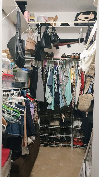 Walk-in closet featuring floor-to-ceiling white wire shelving, multi-level hanging rods, and integrated wire shoe racking