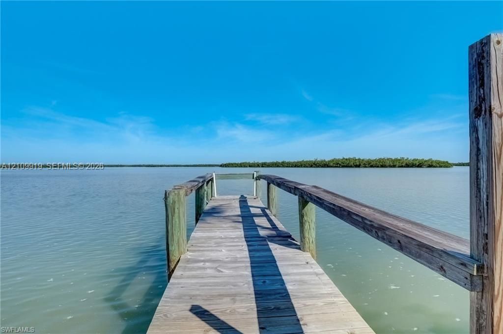 Wooden dock with timber framing and railings extending over the water