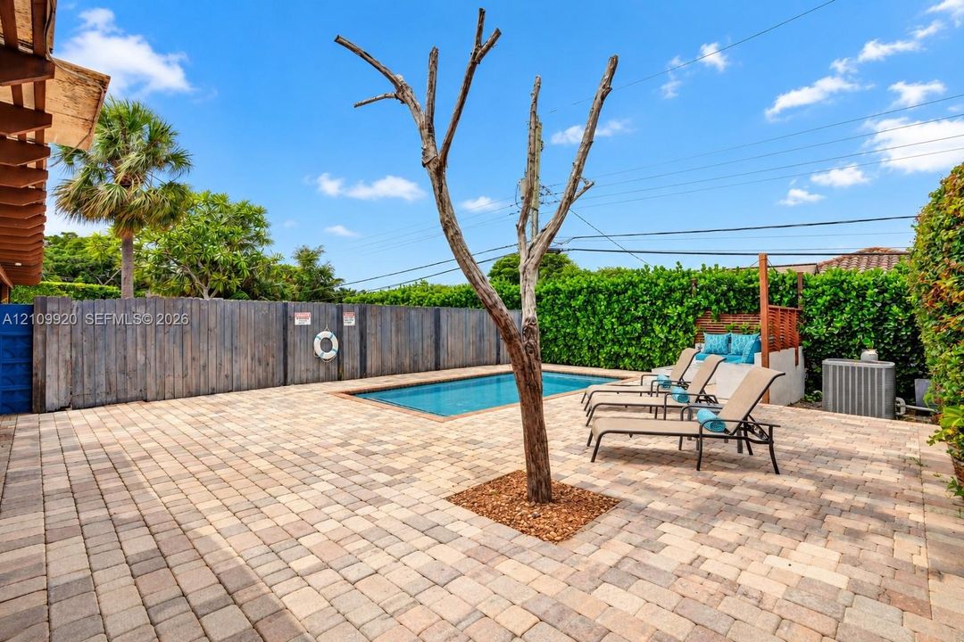 Residence 1753 (Right Side) – Private outdoor oasis featuring a heated swimming pool, built-in seating area, outdoor TV, and a pergola with a newly installed flat roof, all within a fully enclosed backyard designed for relaxation and entertaining.