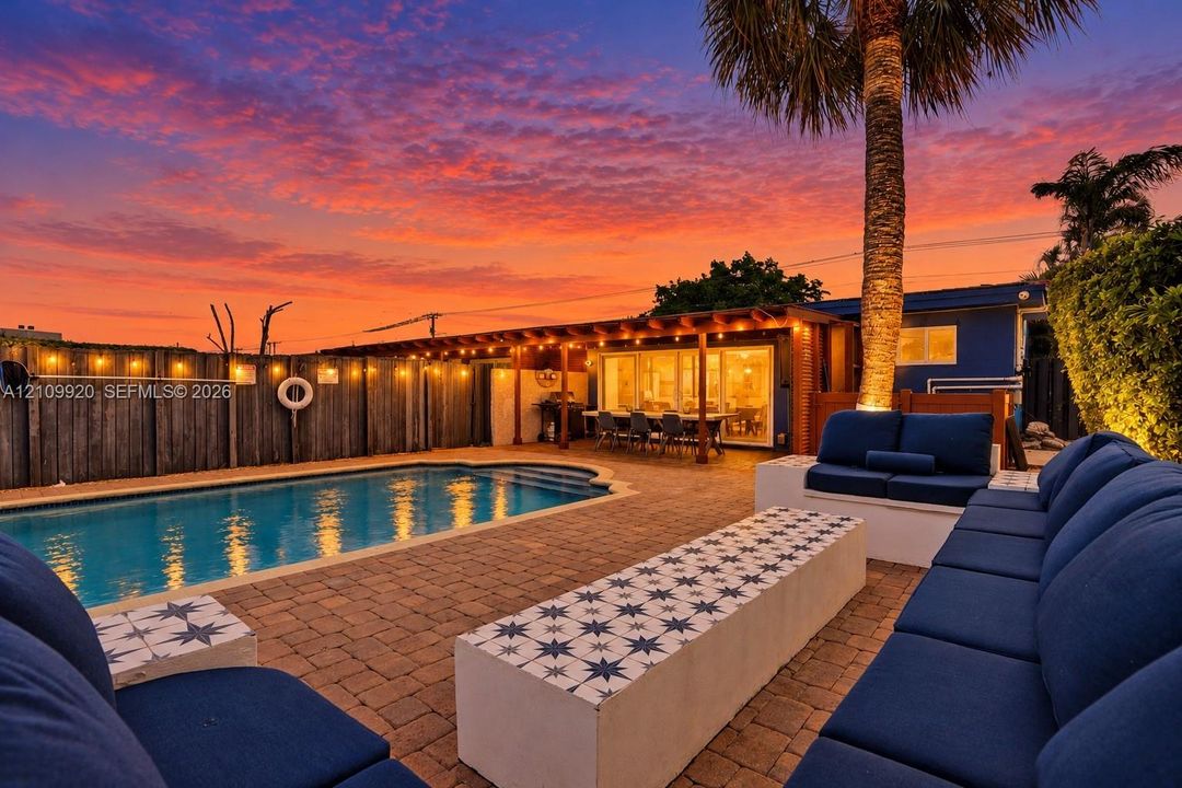 Residence 1747 (Left Side) – Private spacious backyard oasis, heated pool, wooden pergola and new flat roof with outdoor string lights, and a mounted TV. Perfect for outdoor dining, relaxing, and entertaining.