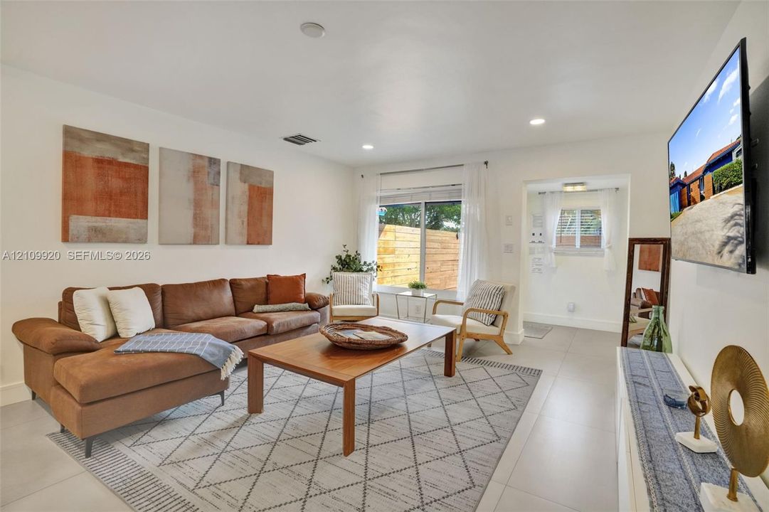 Residence 1747 (Left Side) – Neutral-toned open concept living  recessed LED lighting, and ample natural light from impact windows.