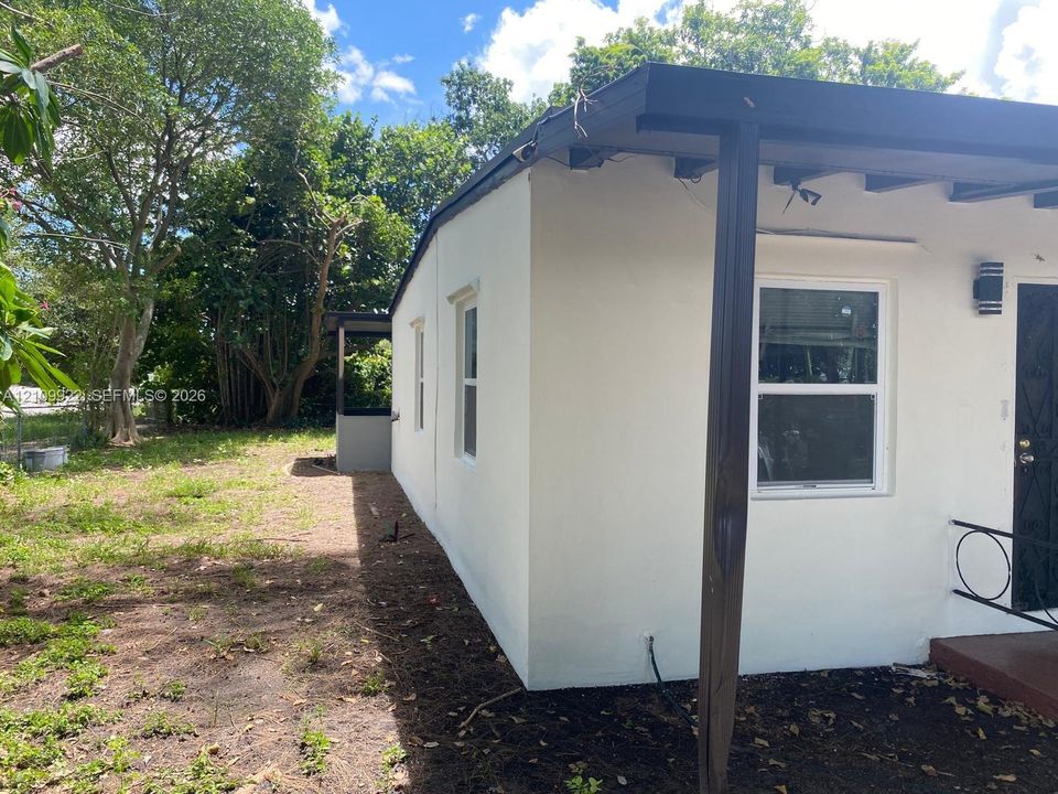 Stucco exterior featuring an attached covered porch with support columns and a metal security door