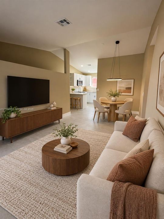 Open-concept interior featuring vaulted ceilings, neutral wall tones, large-format tile flooring, and a modern circular pendant light fixture