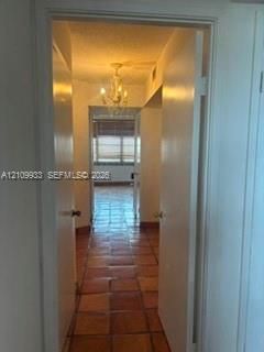 Ceramic tile flooring, classic chandelier, and multi-pane window