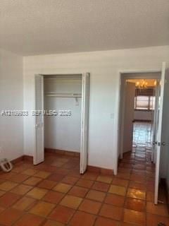 Square terra cotta tile flooring, bifold closet doors, and solid-core interior doors