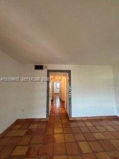 Interior space featuring terracotta tile flooring and a decorative tiled door casing