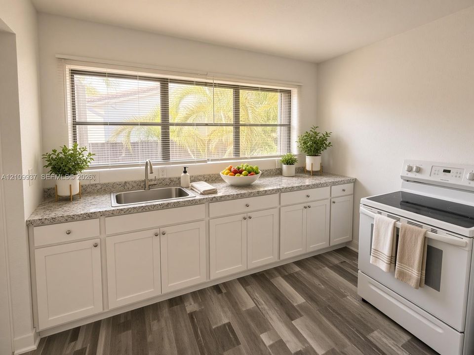 Kitchen featuring white shaker-style cabinetry, stone-finish countertops, stainless steel undermount sink, wood-finish flooring, and a wide window with natural light