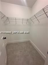 Walk-in closet featuring high ceilings, neutral wall finishes, and tiered wire shelving