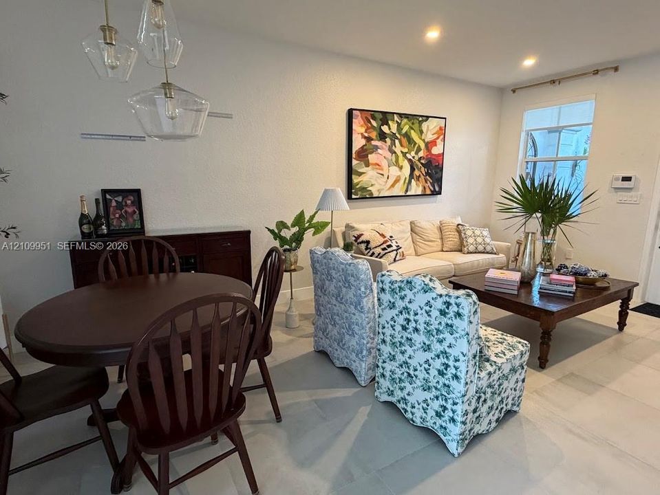 Large-format tile flooring, recessed ceiling lighting, and a multi-pendant geometric glass light fixture