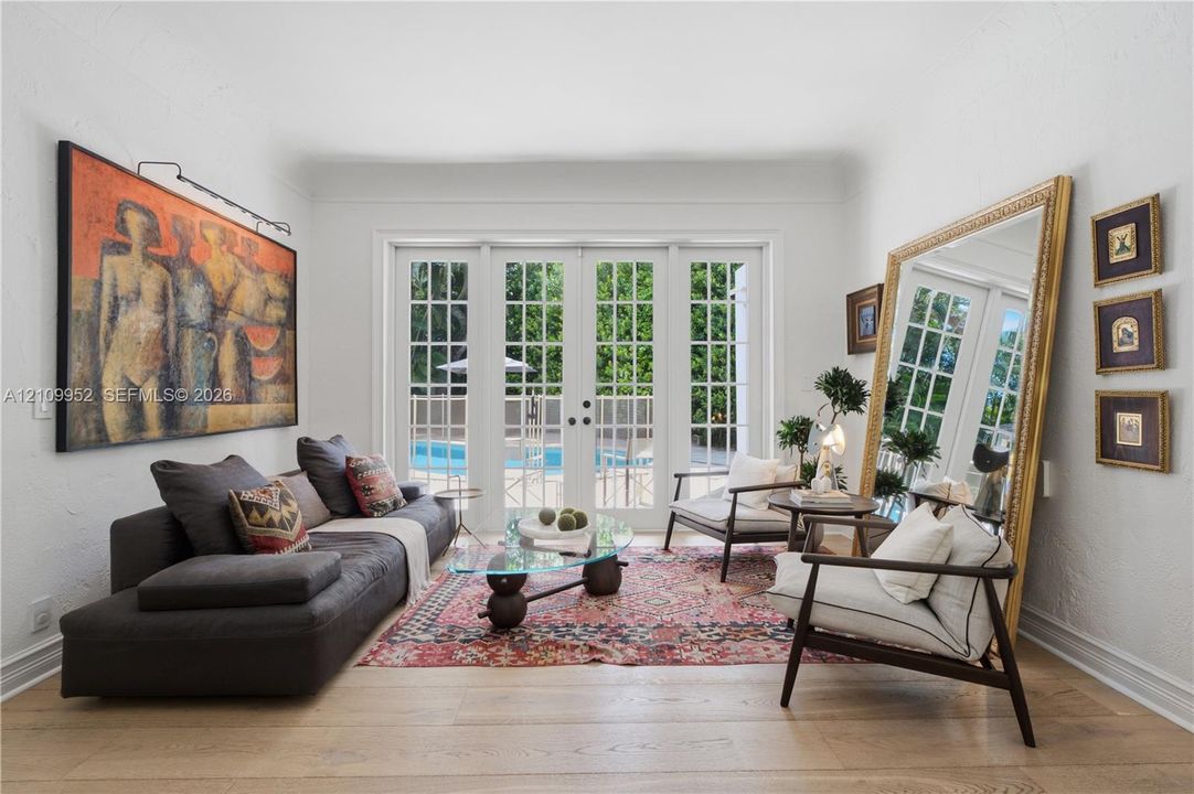 White-walled interior featuring wood-finish flooring and glass-paned double doors with exterior access