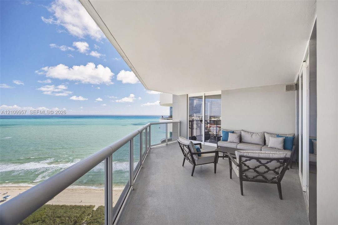 Expansive 29th floor views from covered balcony with metal railing, floor-to-ceiling glass windows, and oceanfront, intracoastal and Biscayne Bay exposures.
