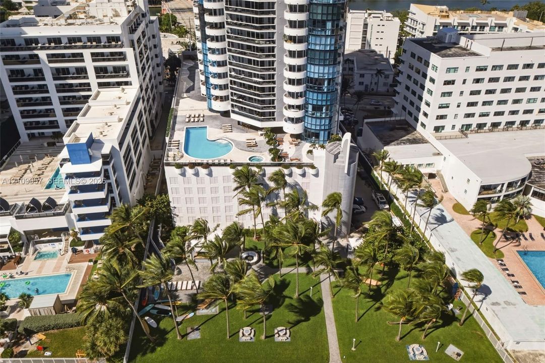 Aerial view of amenity spaces featuring pool, private community summer kitchen and picnic areas overlooking boardwalk.