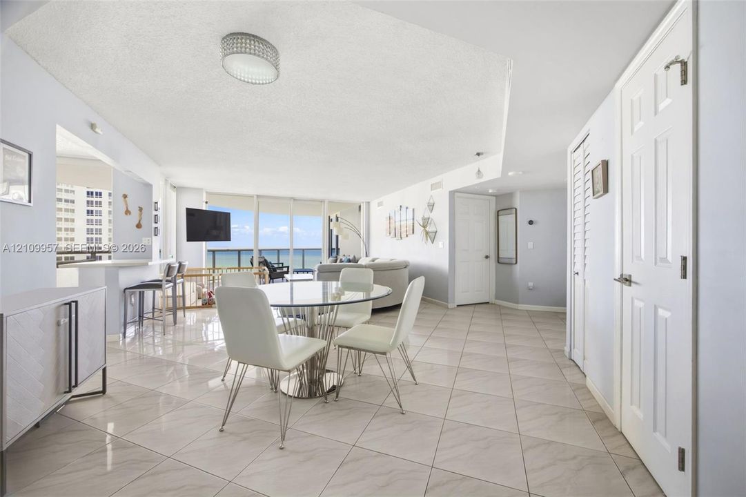 Open-concept living room enveloped in floor-to-ceiling glass walls overlooking the ocean.