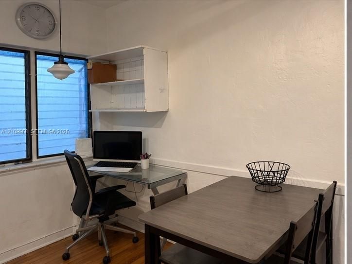 Hardwood flooring, multi-pane window, and wall-mounted white cabinetry