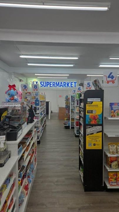 Commercial interior featuring wood-finish flooring, linear LED lighting, and integrated retail shelving units