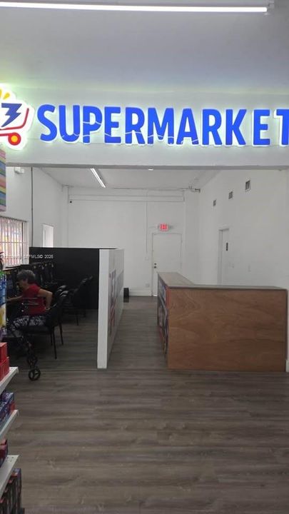 Commercial space featuring wood-finish flooring, built-in service counter, LED interior signage, and recessed lighting