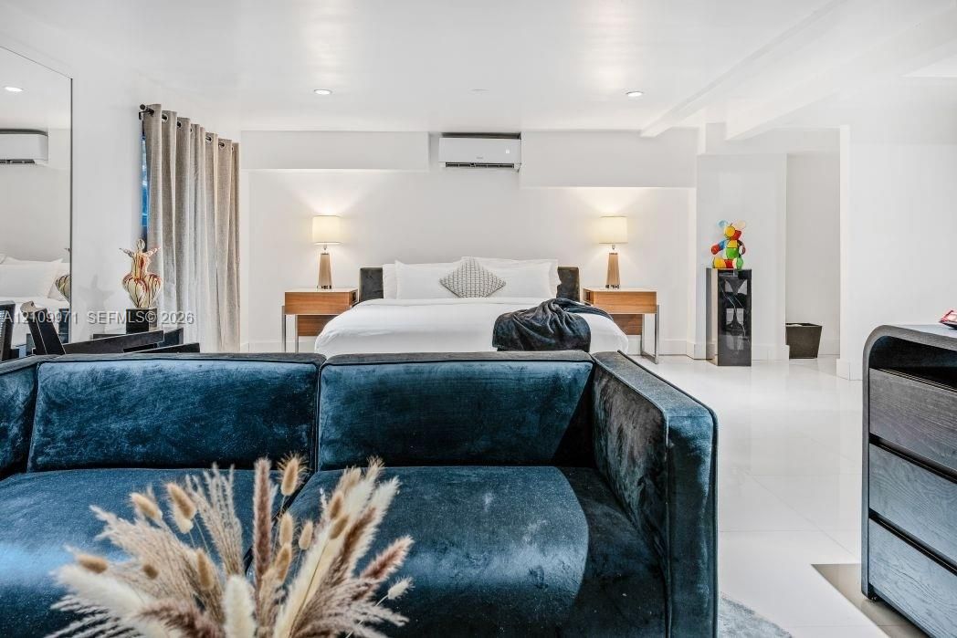 Spacious interior featuring high-gloss flooring, recessed lighting, and a wall-mounted climate control unit