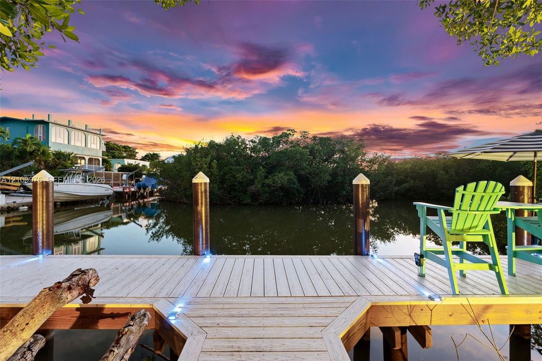 Waterfront dock featuring composite decking, integrated perimeter lighting, and decorative pilings