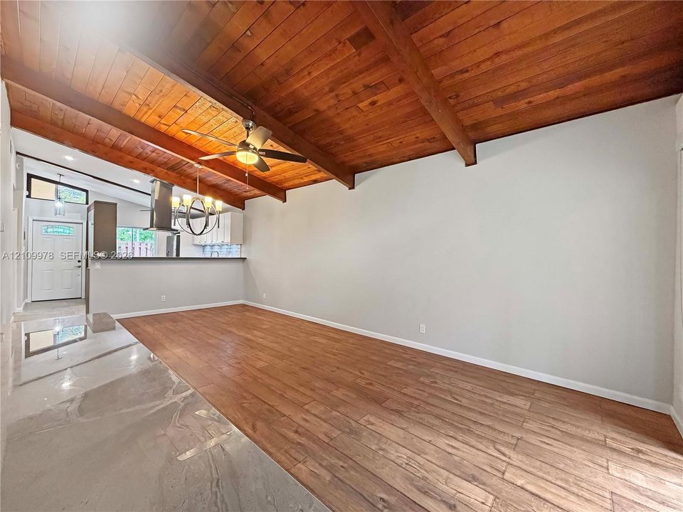 Vaulted ceiling featuring exposed wood beams and wood-plank ceiling finish, wood-finish flooring, and recessed lighting