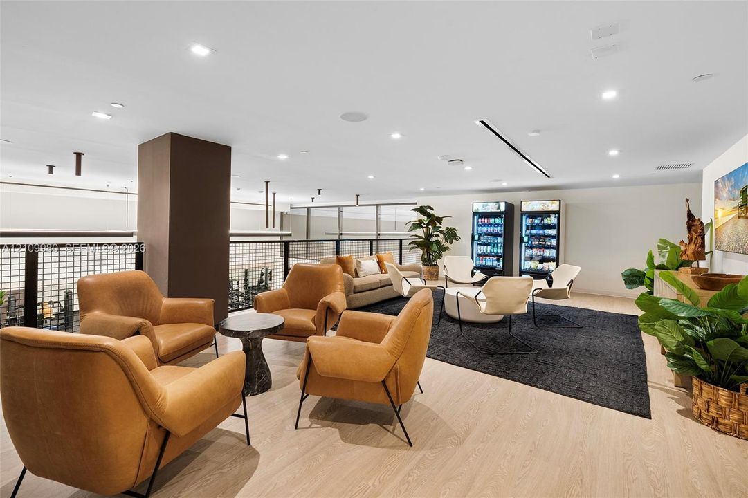 Open-concept lounge featuring wood-finish flooring, recessed lighting, and a metal-grid balcony railing