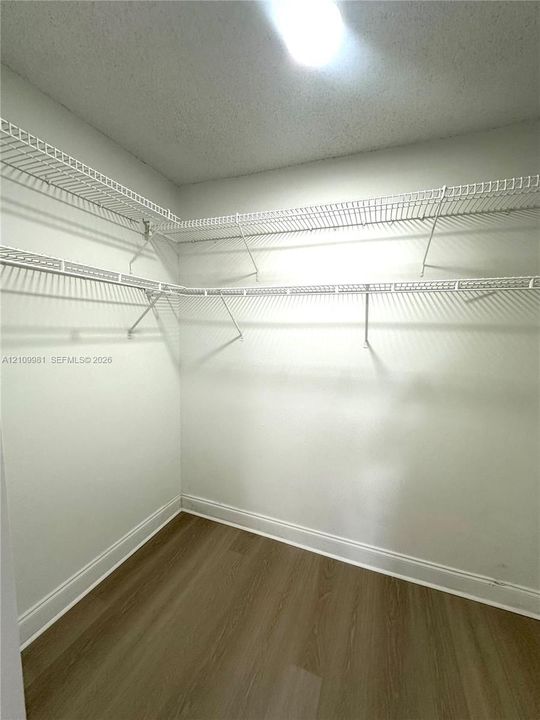 Storage area featuring multi-level wire shelving and wood-finish flooring